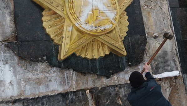Националист сбивает облицовку на Монументе Славы во Львове. Архивное фото