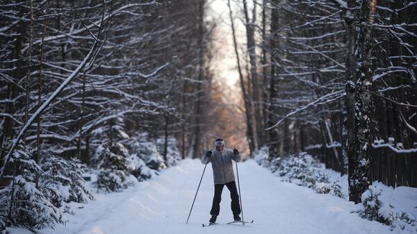 Мужчина катается на лыжах в одном из парков Москвы