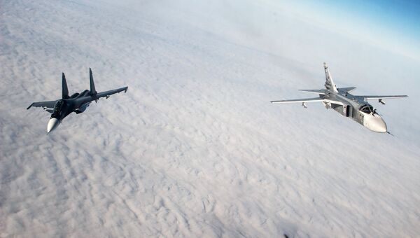 Многоцелевой истребитель Су-30СМ (слева) и тактический фронтовой бомбардировщик Су-24М во время лётно-тактических учений. Архивное фото