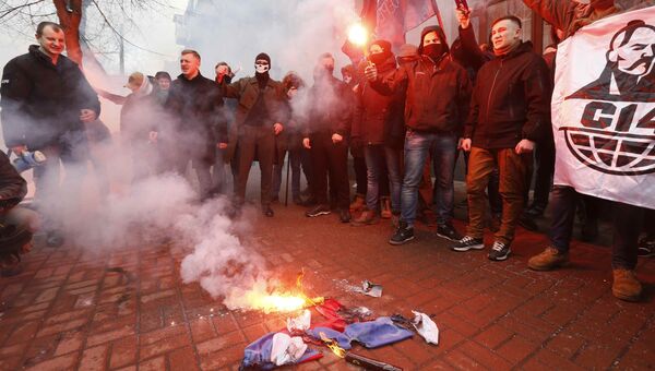 Активисты и сторонники украинских националистических партий сжигают Российский флаг, изьятый из офиса Российского центра науки и культуры в Киеве. 17 февраля 2018
