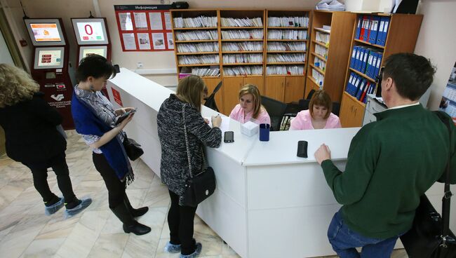 Посетители у регистрационного стола в одной из поликлиник Москвы. Архивное фото