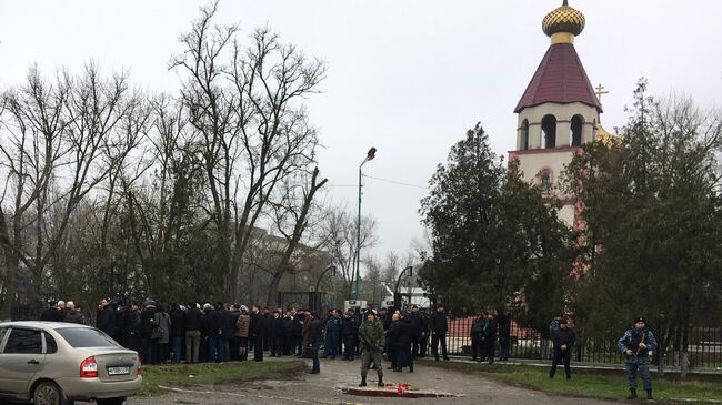 Жители у Свято-Георгиевского храма в Кизляре, где 18 февраля местный житель открыл стрельбу из ружья по прихожанам