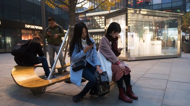 Горожане на территории многофункционального комплекса Sanlitun Soho в Пекине. Архивное фото