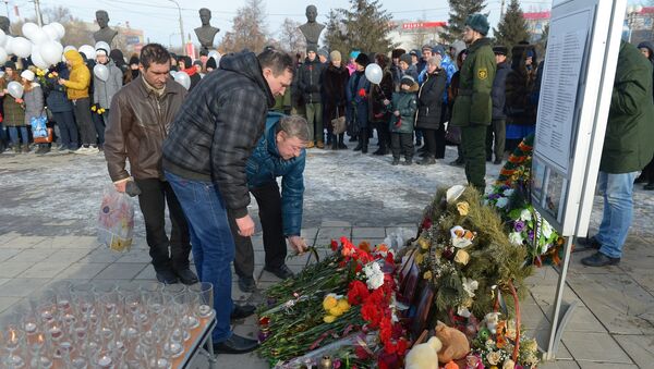 Участники акции Минута памяти в Сквере Славы города Орска, принесшие цветы и игрушки к вечному огню, в память о погибших в авиакатастрофе 11 февраля.