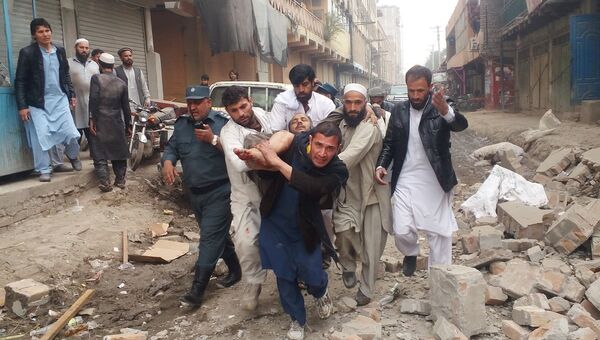 Местные жители несут пострадавшего при взрыве в городе Джелалабад, Афганистан. 20 февраля 2018