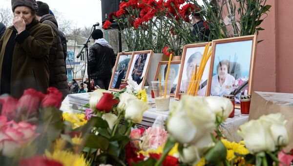 Цветы, свечи и портреты погибших в результате стрельбы у собора Георгия Победоносца в Кизляре во время похорон. 20 февраля 2018