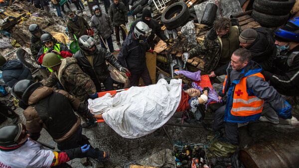 Сторонники оппозиции несут раненного во время столкновений с сотрудниками правопорядка на площади Независимости в Киеве. 20 февраля 2017 