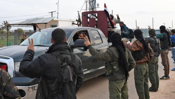 Курдские бойцы приветствуют конвой просирийских правительственных сил, прибывающих в сирийский Африн. 20 февраля 2018