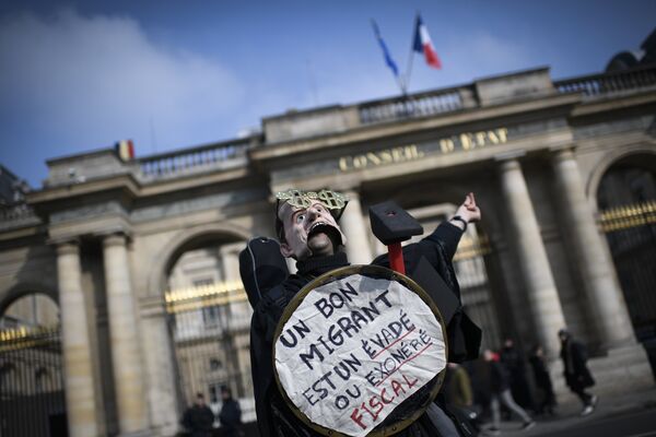 Участник протеста против закона об иммиграции в Париже