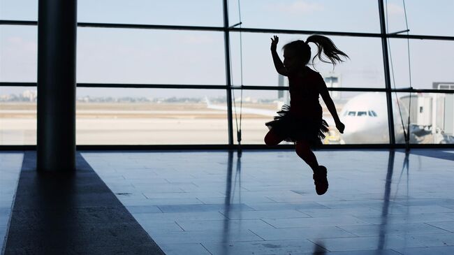 Девочка прыгает в аэропорту