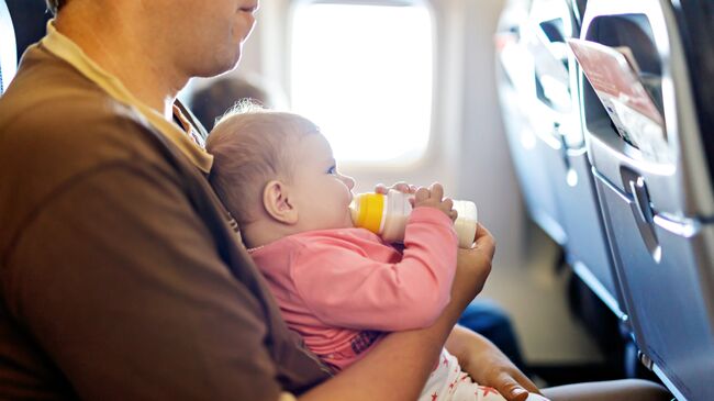 Мужчина с грудным ребенком в салоне самолета