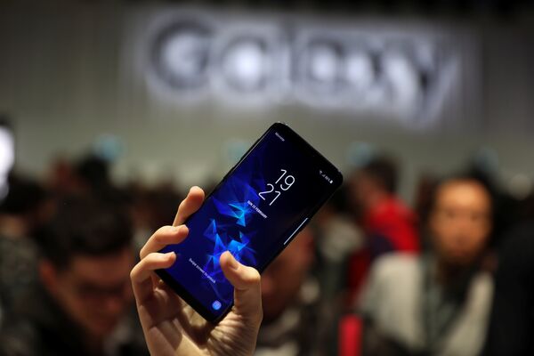 Девушка держит новый смартфон Samsung Galaxy S9 после презентации Mobile World Congress в Барселоне, Испания. 25 февраля 2018 года