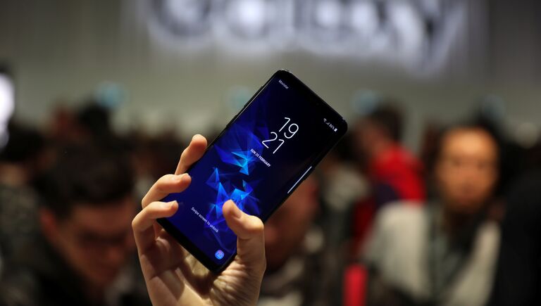 Девушка держит новый смартфон Samsung Galaxy S9 после презентации Mobile World Congress в Барселоне, Испания. 25 февраля 2018 года