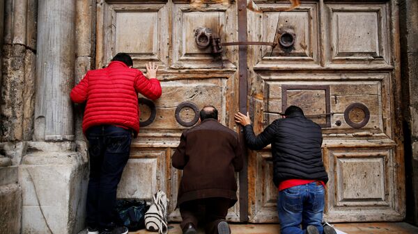 Прихожане молятся у дверей закрытого Храма гроба Господня в Иерусалиме. 25 февраля 2018