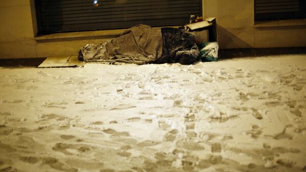 Бездомный спит на улице в городе Исси-ле-Мулино к западу от Парижа во время снегопада