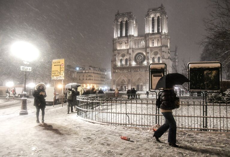 Прохожие возле Собора Парижской Богоматери (Notre-Dame de Paris) во время снегопада в Париже