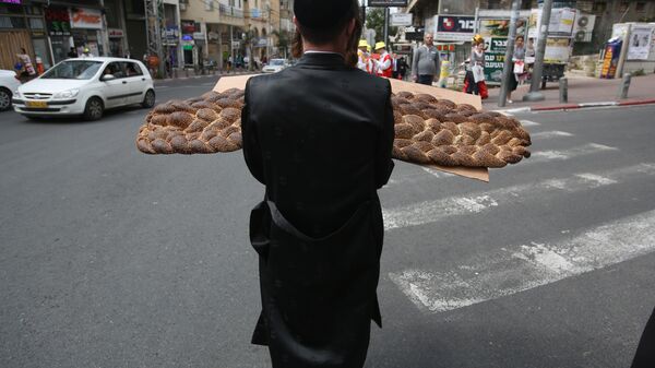 Ультраортодоксальный еврей с хлебом во время празднования Пурима в городе Бней-Брак, Израиль 