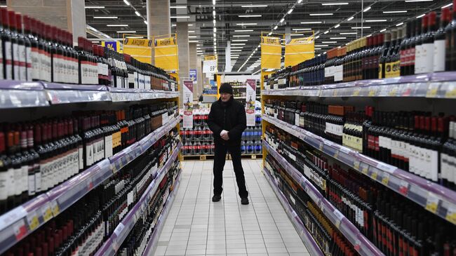 Покупатель в отделе алкогольной продукции в супермаркете. Архивное фото