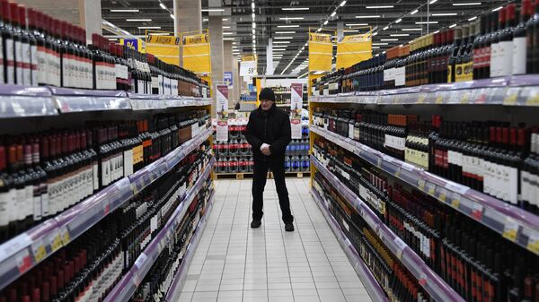 Покупатель в отделе алкогольной продукции в супермаркете