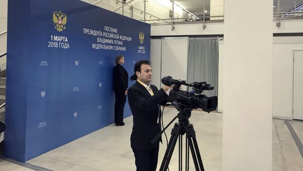 Журналисты фотографируются на фоне стенда Послание Президента Российской Федерации