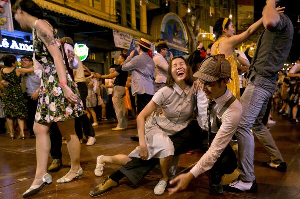 Люди танцуют на улице перед Пхра Патом Чеди в провинции Накхонпатхом в Таиланде