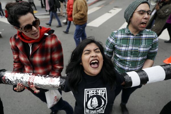 Молодый люди блокируют перекресток перед зданием Им­миг­ра­ци­он­ной и таможенной полиции США во время протеста в Сан-Франциско.  28 февраля 2018 года