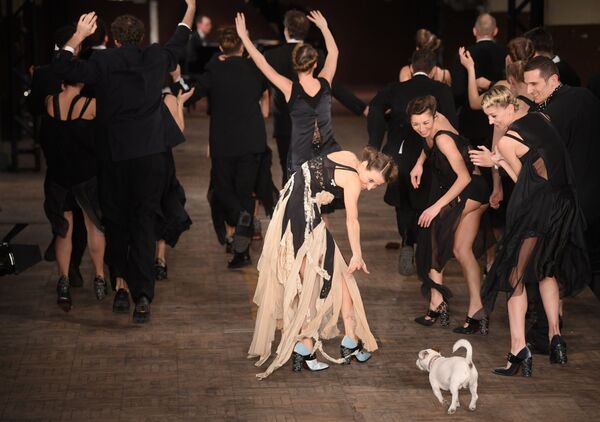 Модели танцуют с собакой на сцене, в конце показа шоу дизайнера Антонио Марраса в Милане