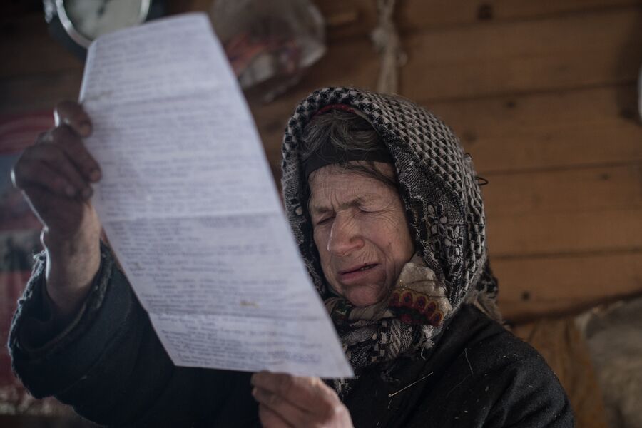 Агафья Лыкова читает письмо, отправленное ей из Боливии 