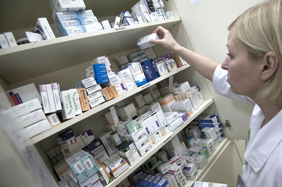 Сотрудница аптеки разбирает лекарства