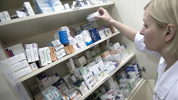 Сотрудница аптеки разбирает лекарства. архивное фото