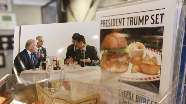 Реклама набора Трампа в японском фаст-фуде Munch's Burger Shack, еду из которого пробовал американский президент во время визита в Токио. 16 ноября 2017