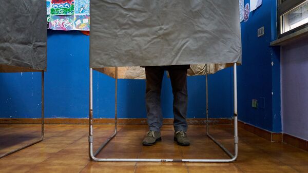 Избиратель в кабинке для голосования на одном из избирательных участков Рима во время парламентских выборов в Италии. 4 марта 2018
