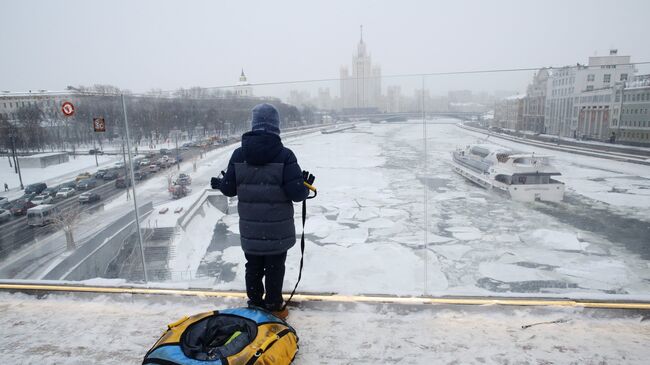 Молодой человек на Парящем мосту парка Зарядье в Москве. архивное фото