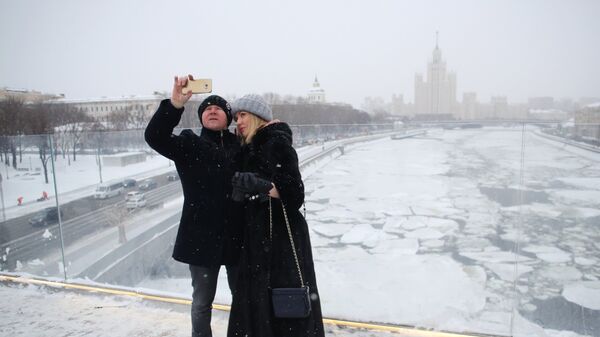 Люди фотографируются на арке Парящего моста парка Зарядье в Москве