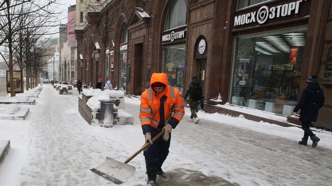 Сотрудник коммунальных служб убирают последствия снегопада на Тверской улице в Москве