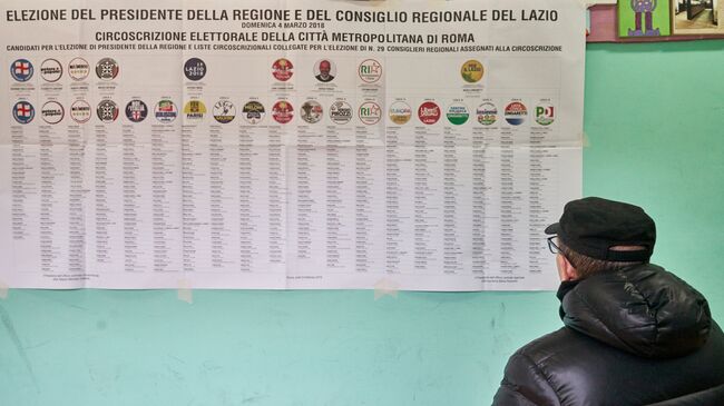 Житель Рима на одном из избирательных участков города изучает список партий, выдвинувших кандидатуры будущих депутатов и сенаторов на парламентских выборов в Италии