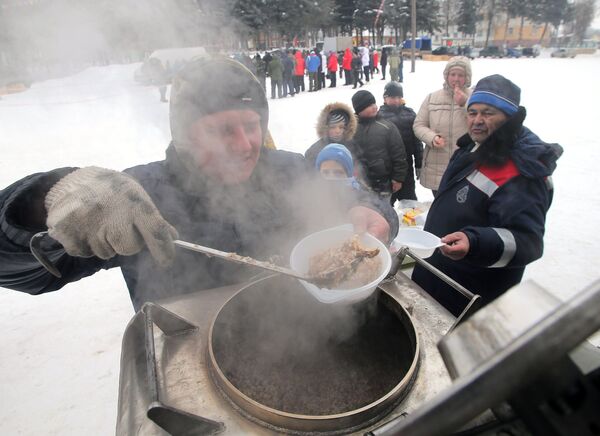 Мужчина накладывает еду в тарелки для посетителей седьмого всероссийского турнира Гусиные бои в посёлке Дубна Тульской области