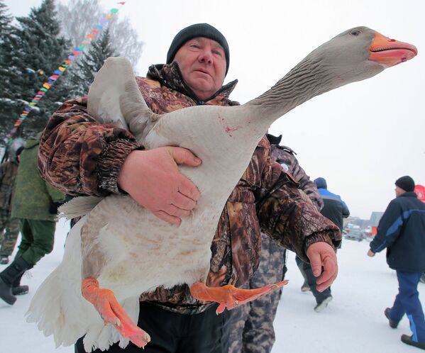 Мужчина несет гуся на седьмом всероссийском турнире Гусиные бои в посёлке Дубна Тульской области