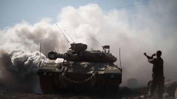 Израильский солдат и танк на Голанских высотах в районе границы с Сирией. Архивное фото