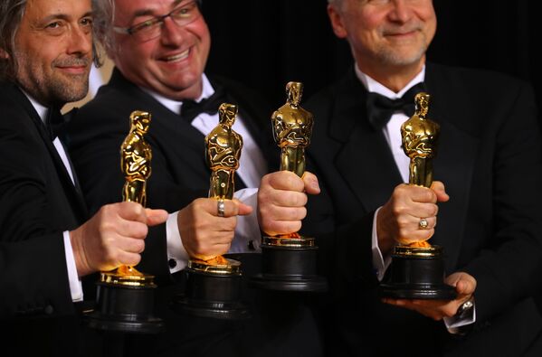 Джон Нельсон, Герд Нефзер, Пол Ламберт и Ричард Р. Гувер демонстрируют статуэтки на церемонии вручения премии Оскар