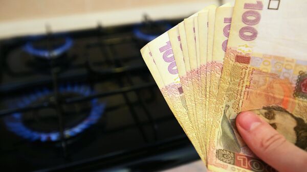 Горящая газовая конфорка и денежные купюры Украины. Архивное фото