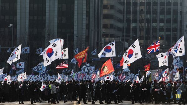 Участники митинга с флагами Южной Кореи и США на одной из улиц в Сеуле