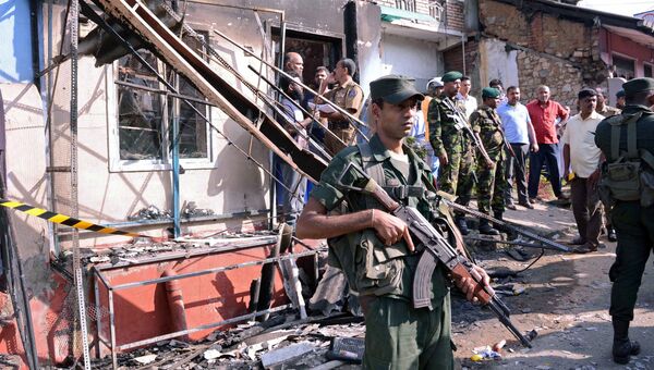 Вооруженные силы Шри-Ланки возле сожженного дома после столкновения между двумя общинами в Дигане, центральном районе Канди. 6 марта 2018
