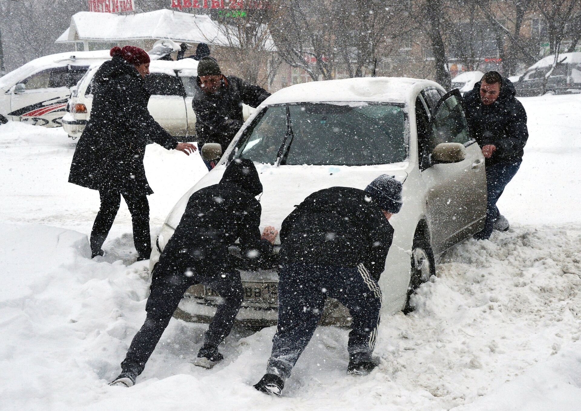Люди выталкивают машину из сугроба на одной из занесенных снегом улиц Владивостока. 8 марта 2018 - РИА Новости, 1920, 31.12.2021