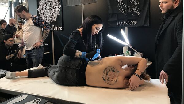 Мастер во время работы на тату-конвенте в Париже. 9 марта 2018