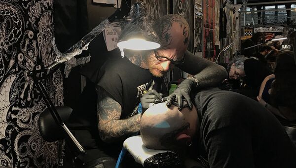 Мастер во время работы на тату-конвенте в Париже. 9 марта 2018