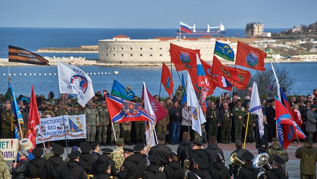 Участники митинга в честь третьей годовщины воссоединения Крыма с Россией на мысе Хрустальный в Севастополе