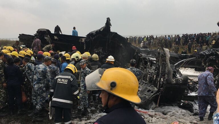 Спасатели на месте крушения самолета авиакомпании US-Bangla Airlines в Катманду, Непал. 12 марта 2018