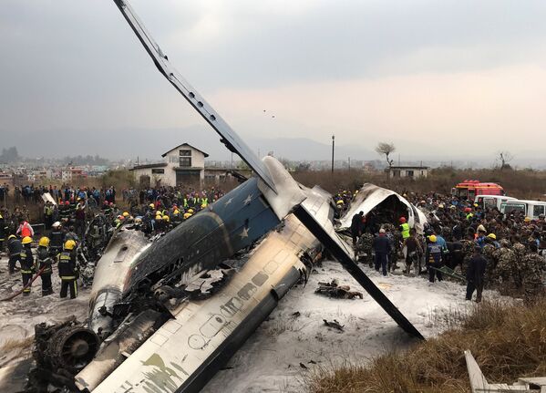 Спасатели на месте крушения самолета авиакомпании US-Bangla Airlines в Катманду, Непал. 12 марта 2018