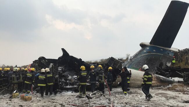 Спасатели на месте крушения самолета авиакомпании US-Bangla Airlines в Катманду, Непал. 12 марта 2018